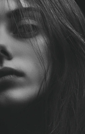 Close-up of a perfectly blended skin fade under dramatic lighting with a matte black background.