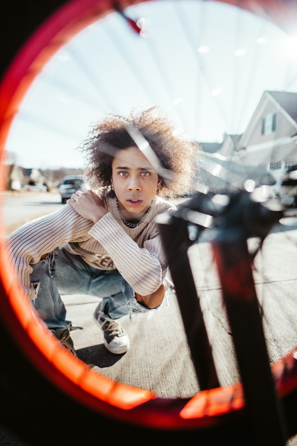 man almost sitting on ground near vehicle