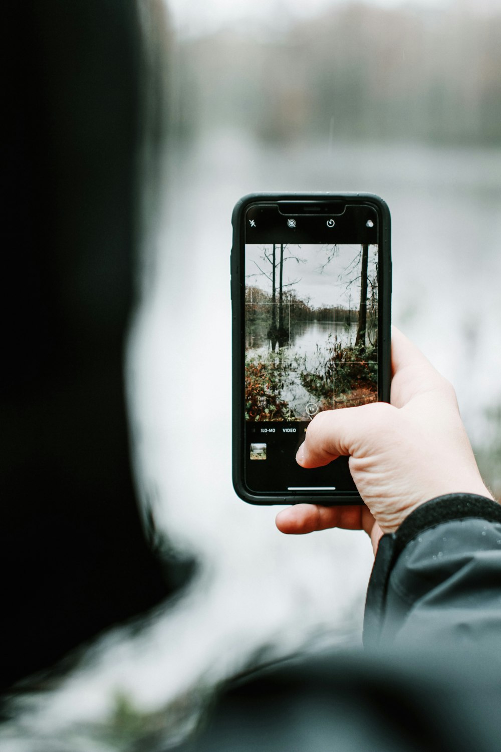 person taking photo of lake