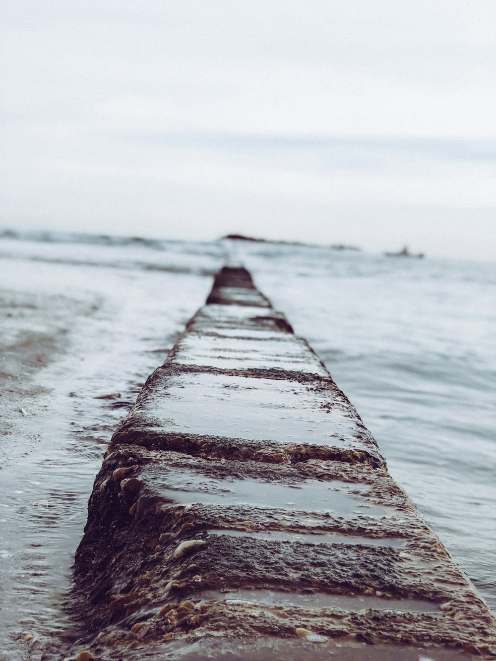 a long wooden pier sitting in the middle of a body of water