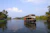 A peaceful houseboat gliding through the lush green Kerala backwaters at sunset.