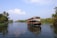 A serene houseboat gliding through Kerala’s lush backwaters at sunset.
