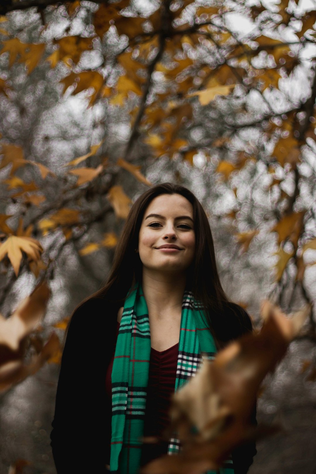 smiling woman standing near tree