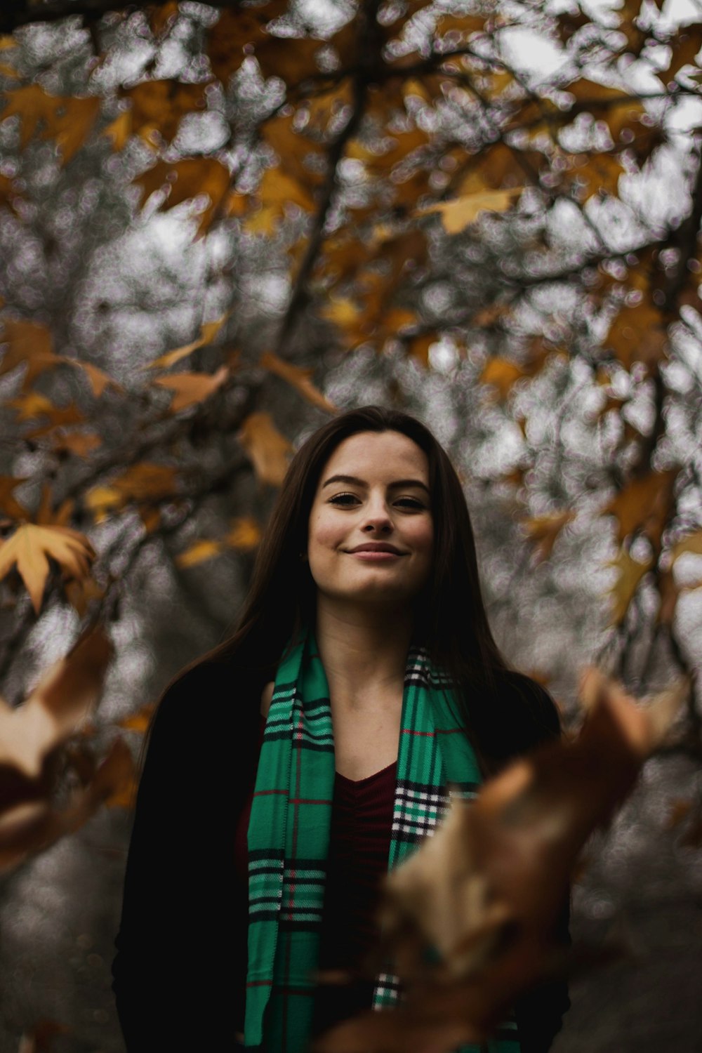 smiling woman standing near tree