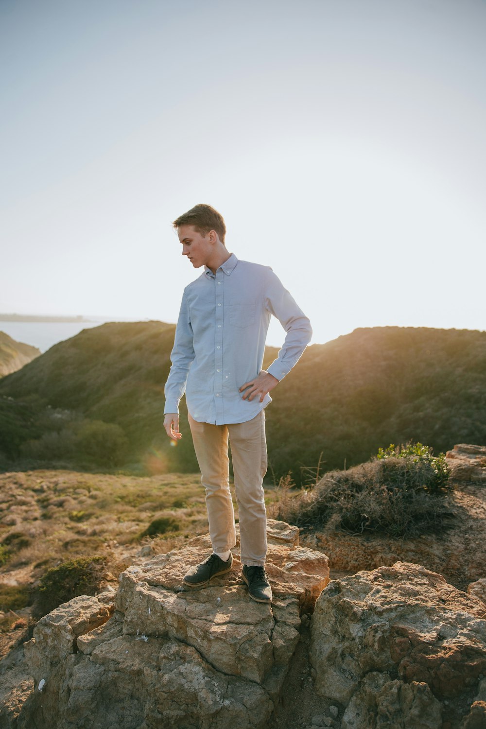 man standing on rock looking down during day