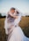 smiling newly wed couple about to kiss in green field