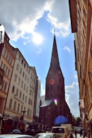 A bustling urban church with diverse congregants gathered outside on a sunny day.