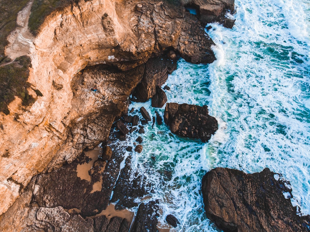 aerial photography of mountain cliff beside beach