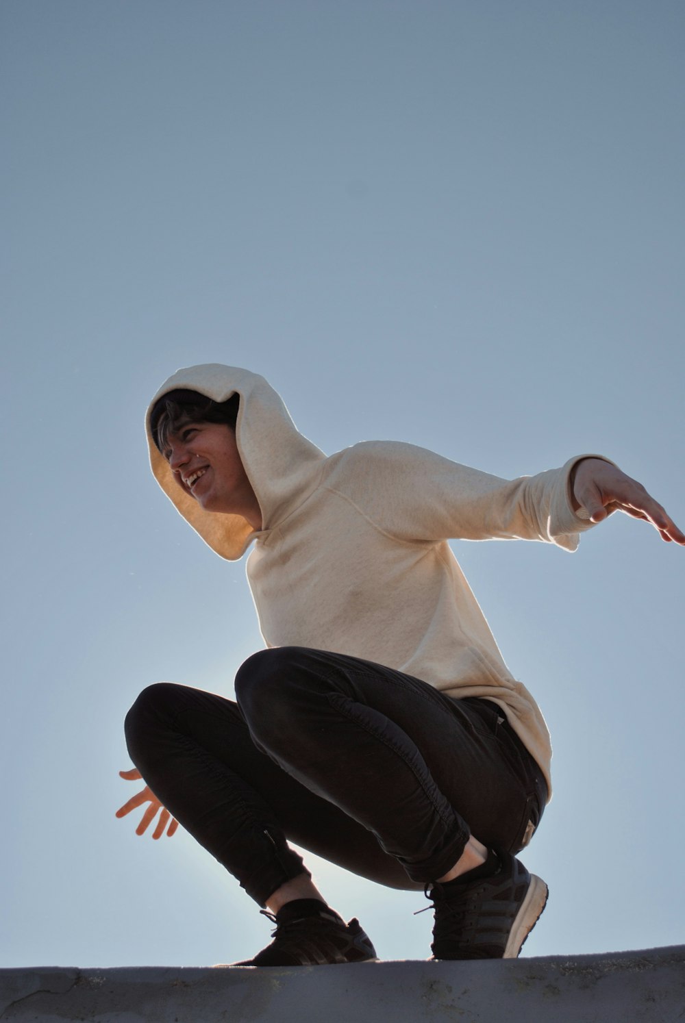 man wearing white hooded sweater and black pants