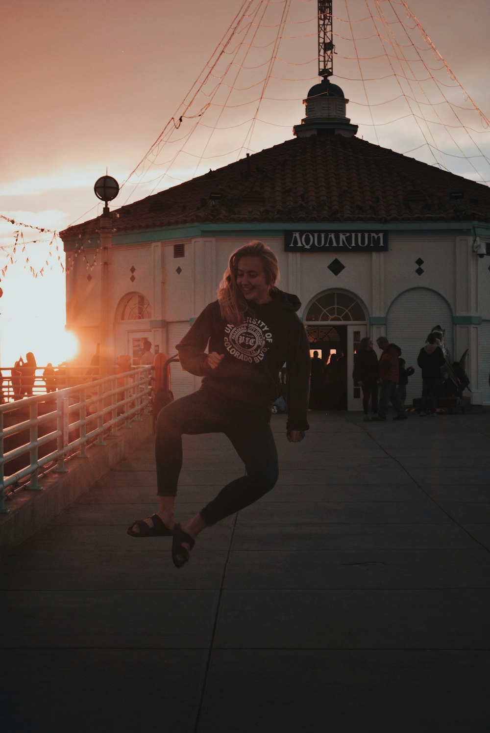 woman jumping in front of Aquakjuim building