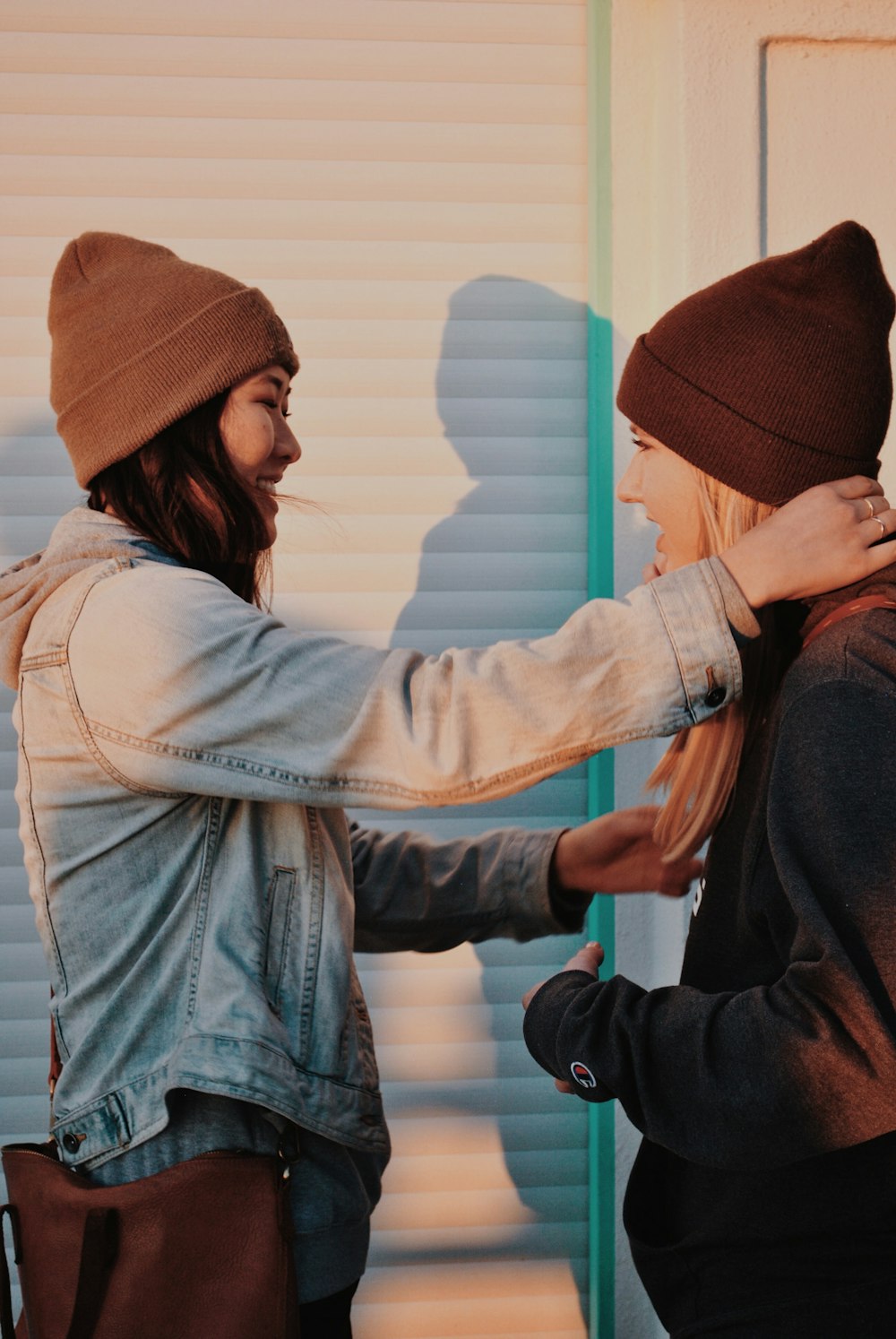 femme souriante debout et touchant le cou d’une autre femme