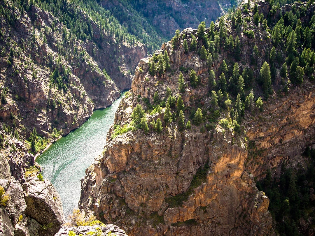 a river flowing through a canyon surrounded by mountains, The Gunnison River bends around the gorge of the Black Canyon 