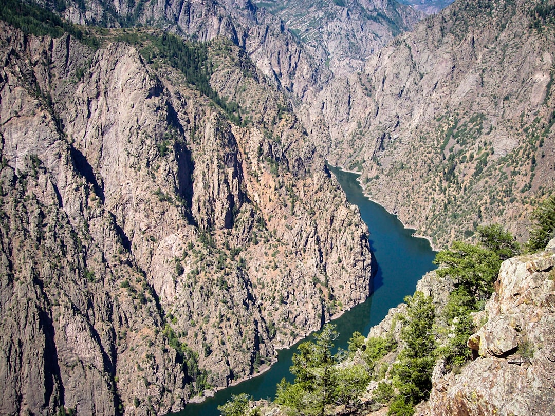 a view of a river surrounded by mountains, The Gunnison River bends through the Black Canyon of the Gunnison National Park.