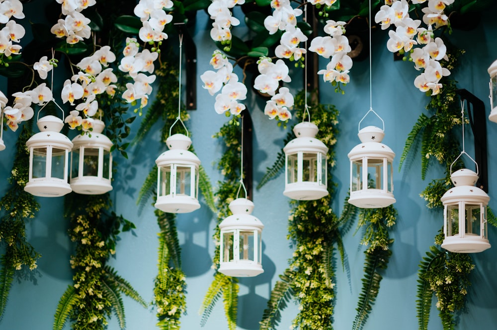 seven hanging white tubular candle lanterns