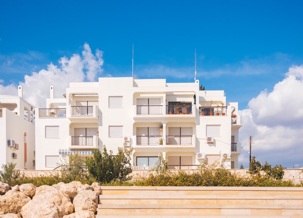 Casa in cemento bianco che si affaccia su nuvole bianche e cielo blu