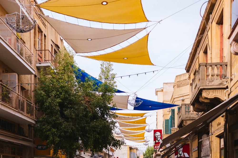 low angle photography of yellow canopy between buildings