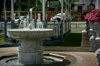 Detail of a marble fountain with water gently flowing, set in an elegant courtyard.