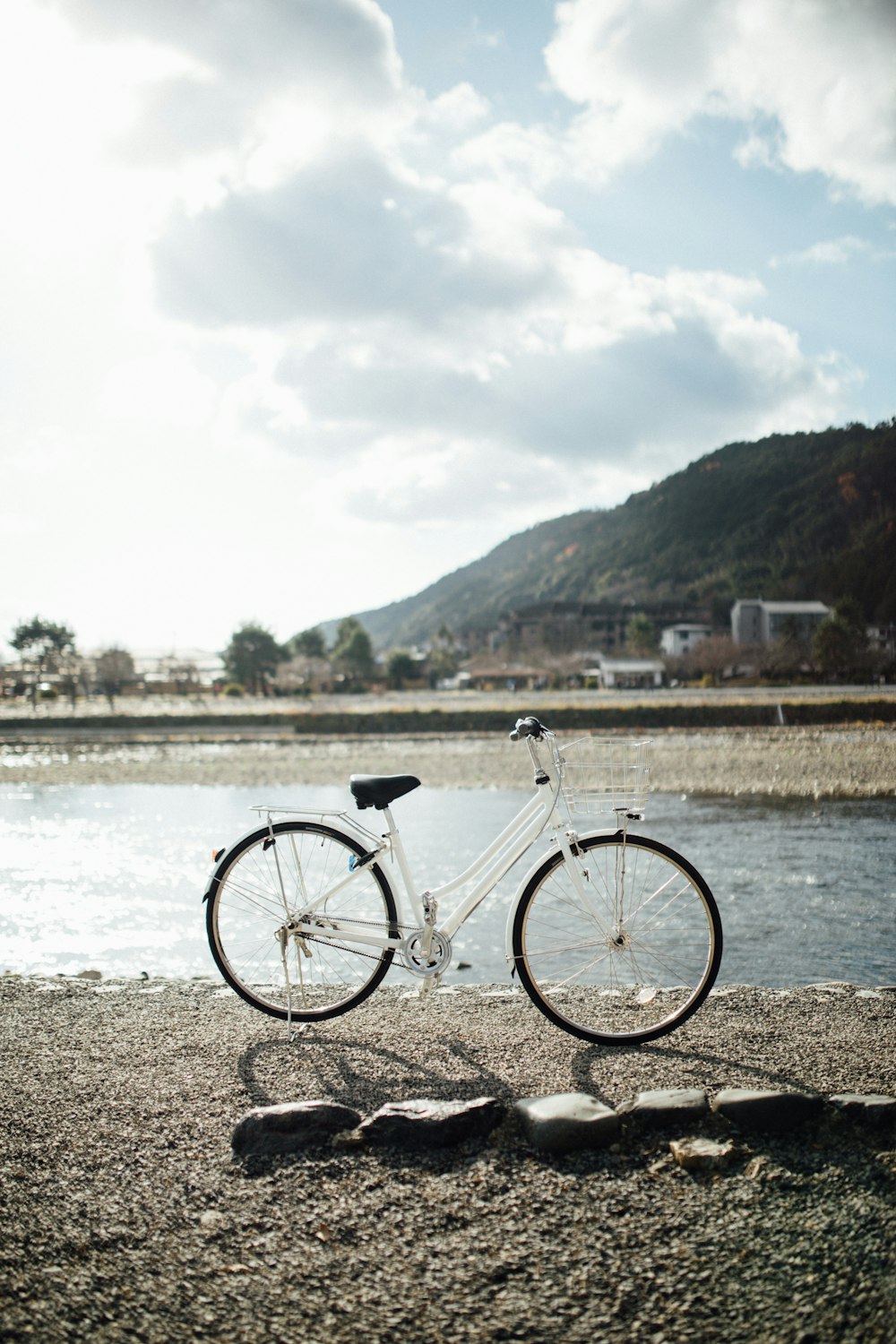 white city bike parked near body of water during daytime