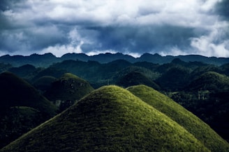 Rolling green hills under a cloudy sky, showcasing Ireland’s peaceful countryside.