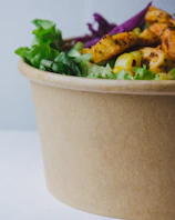 Close-up of a colorful protein-packed salad bowl with fresh vegetables and grilled chicken.