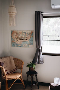 A portable AC unit on wheels placed next to a cozy reading nook.