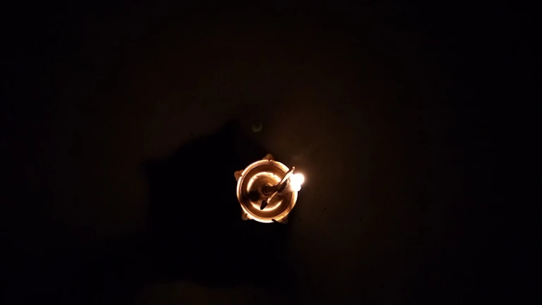 A glowing yantra diagram illuminated by candlelight during a ritual.