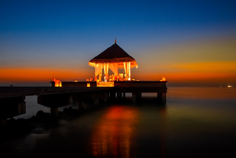 brown gazebo on dock over body of water