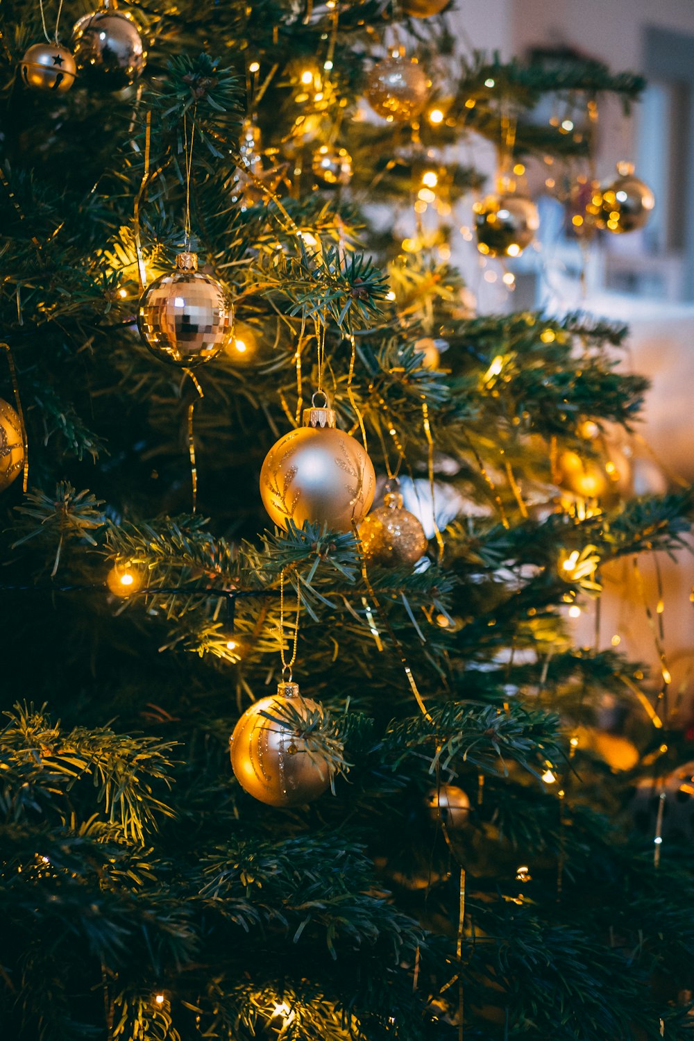 selective focus photography of baubles and string lights on Christmas tree