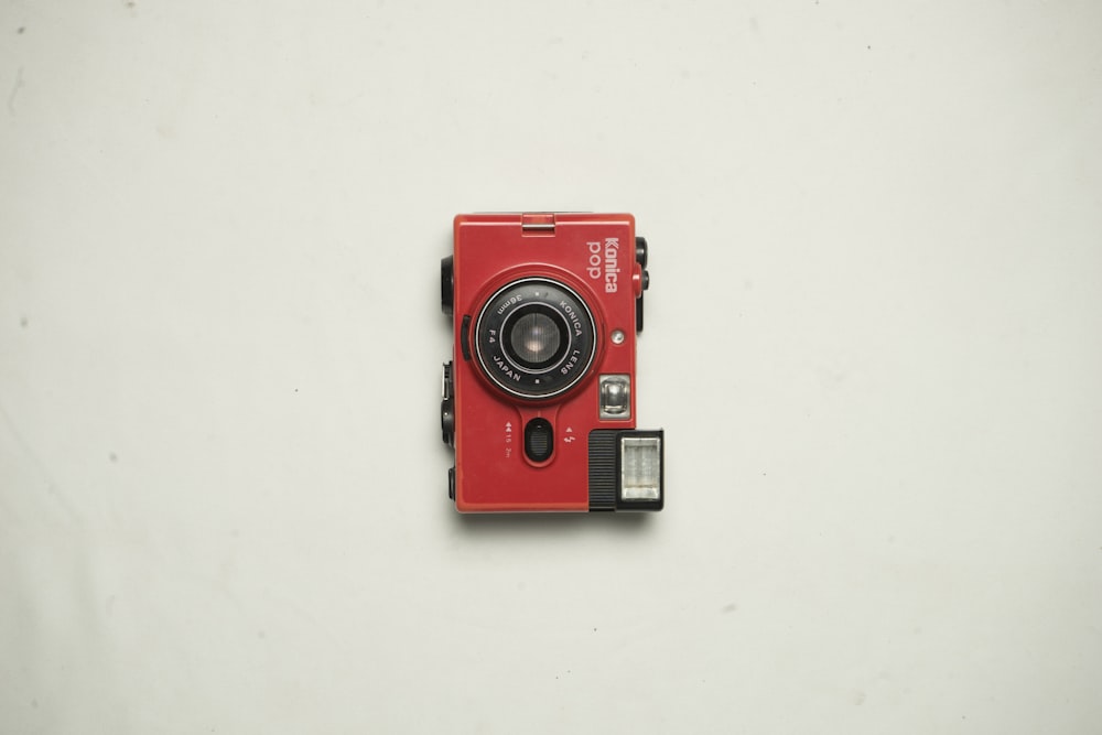 red and black Konica point-and-shoot camera