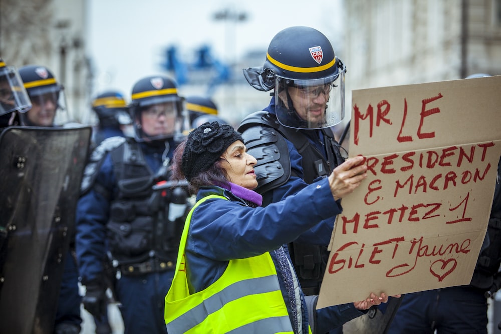 officer beside woman holding poster