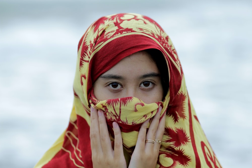 shallow focus photography of woman wearing red and yellow hijab headdress
