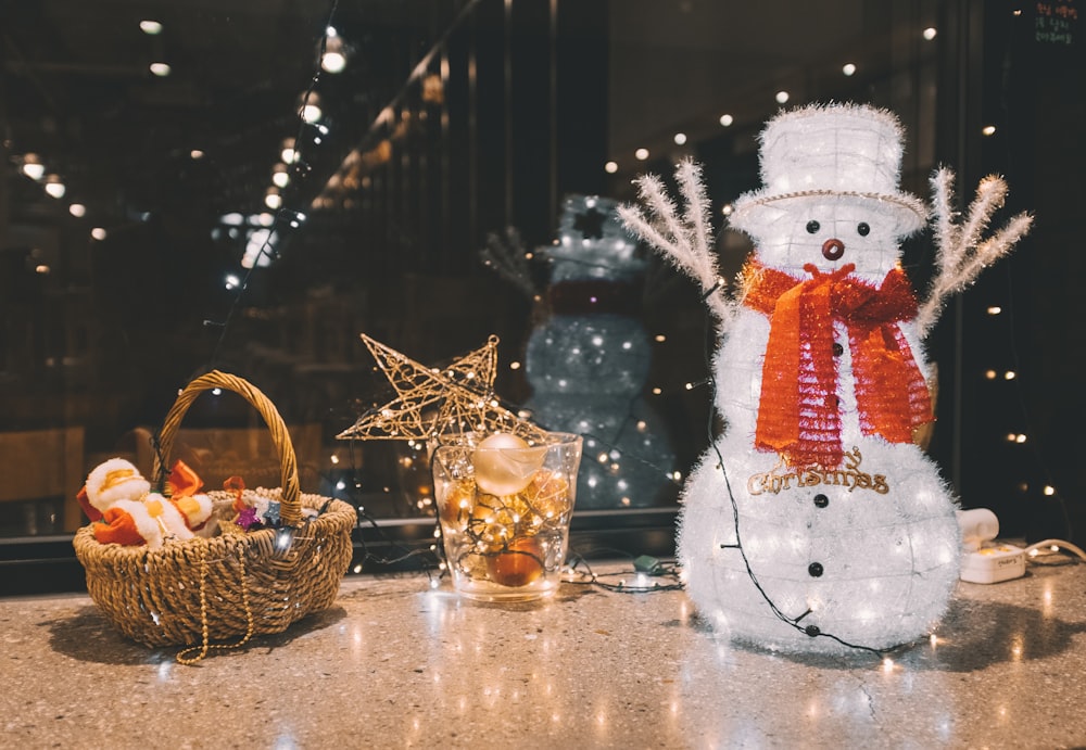 wicker basket, drinking glass, and snowman figurine