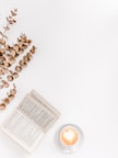 white ceramic mug beside white book