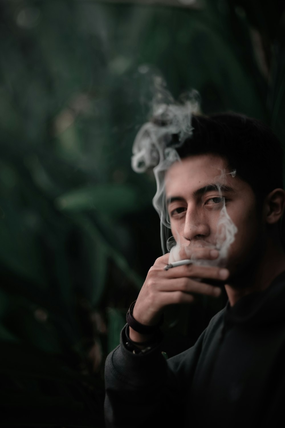 Hombre fumando cerca del jardín