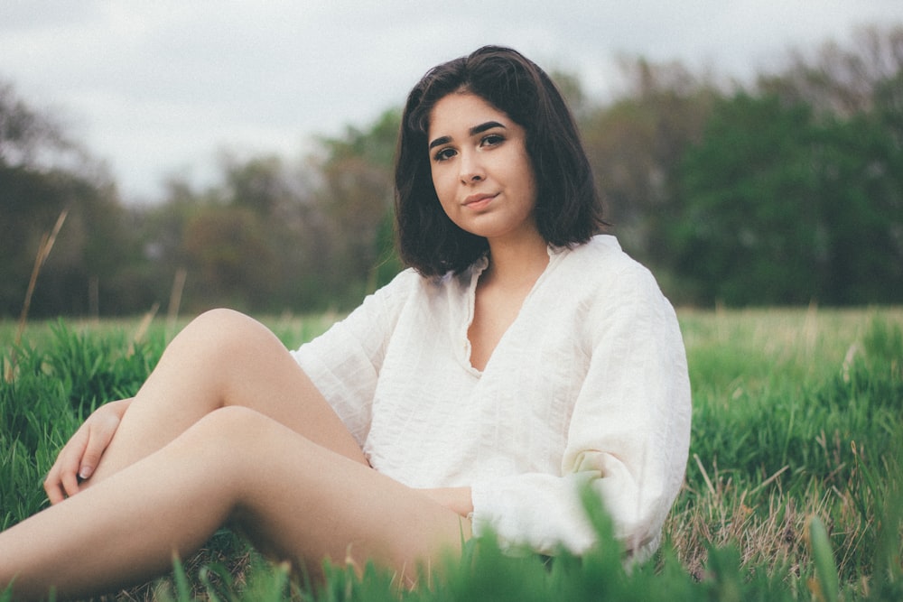 woman sitting on green grass field