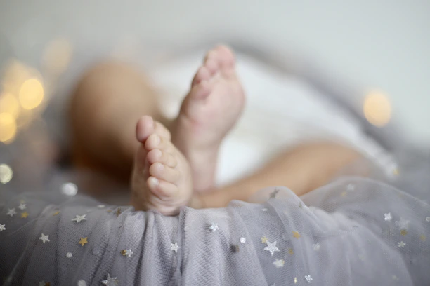 Close-up of delicate baby feet casting in soft golden light.