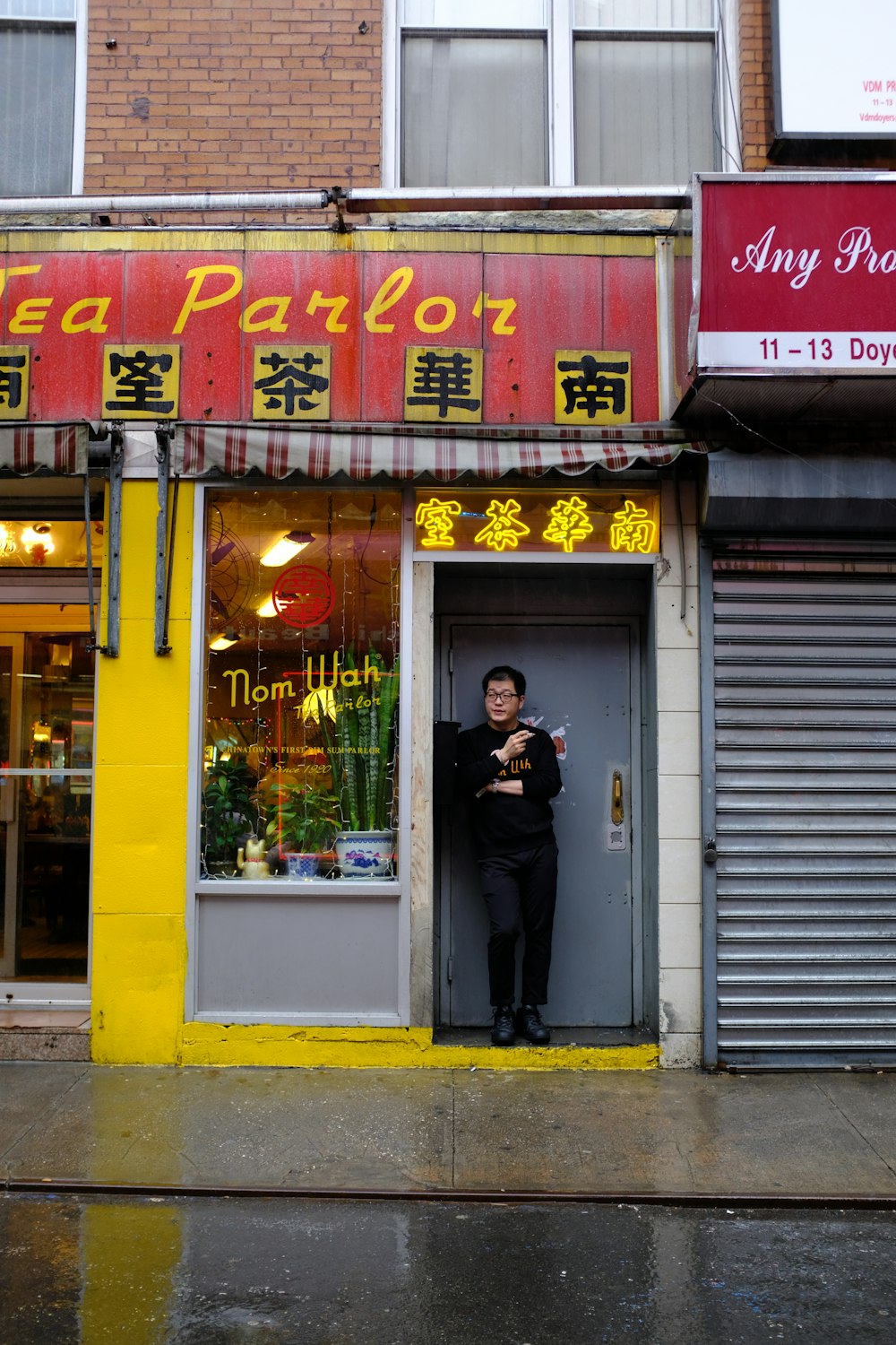 man standing beside shop door