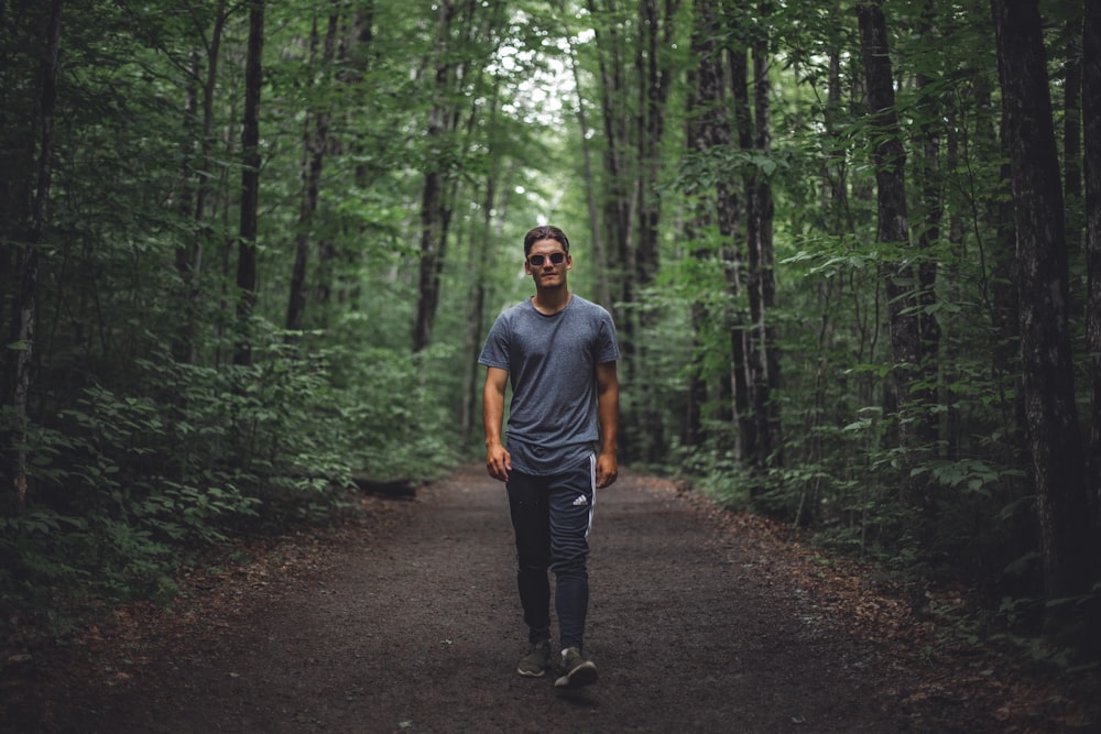 man walking under forest