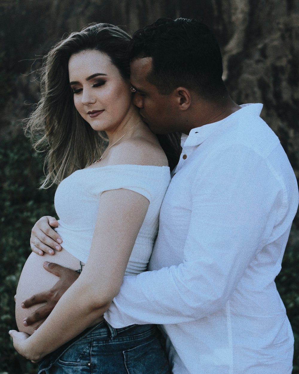 man kissing woman on neck