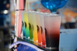 An artistic display of colorful laboratory drinks in glass beakers.