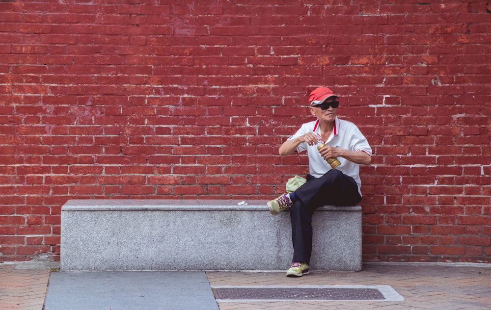 man sitting on concrete surface