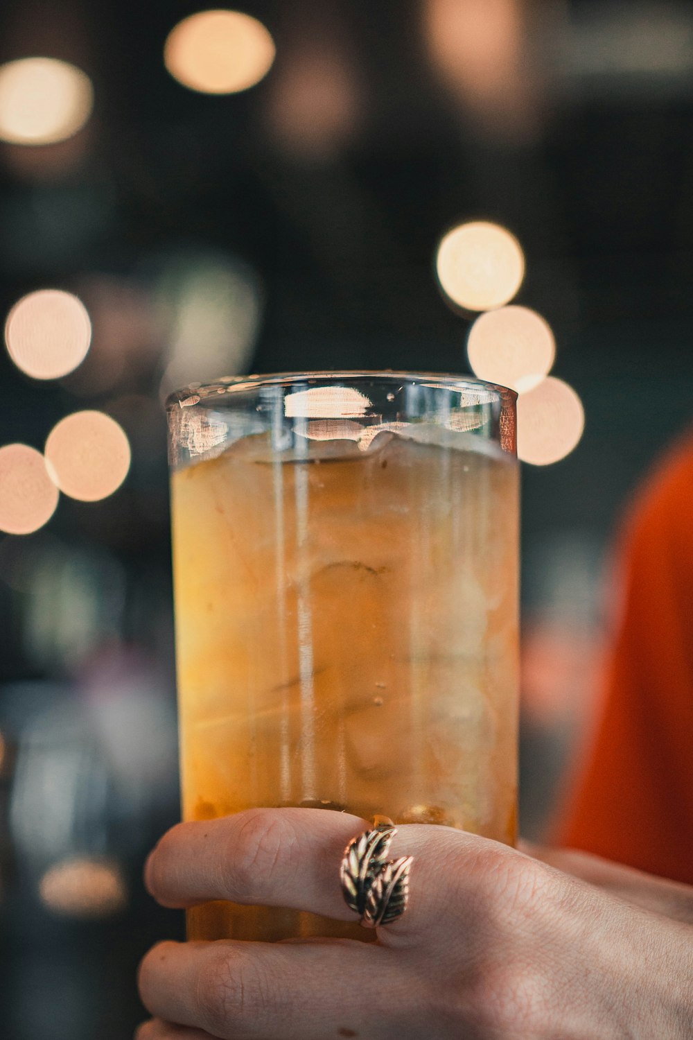 person holding clear drinking glass with juice