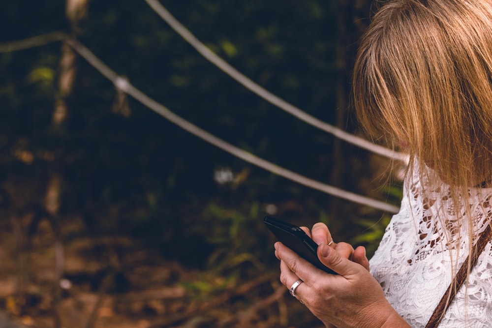 woman using black smartphone outdoor