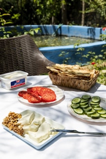A delicious spread of fresh food and drinks served on a wooden table near the pool