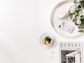 Flat lay of a journal, a cup of herbal tea, and a smartphone showing the Daily Biohack Instagram page.