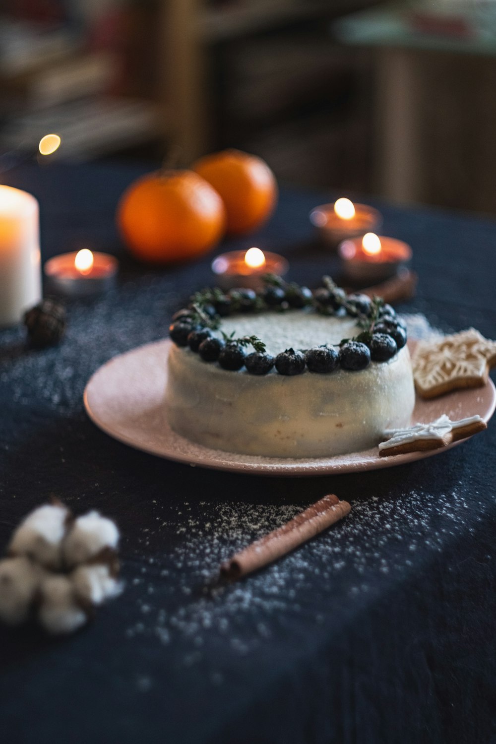 Kuchen mit Brombeeren auf dem Teller neben Teelichtern