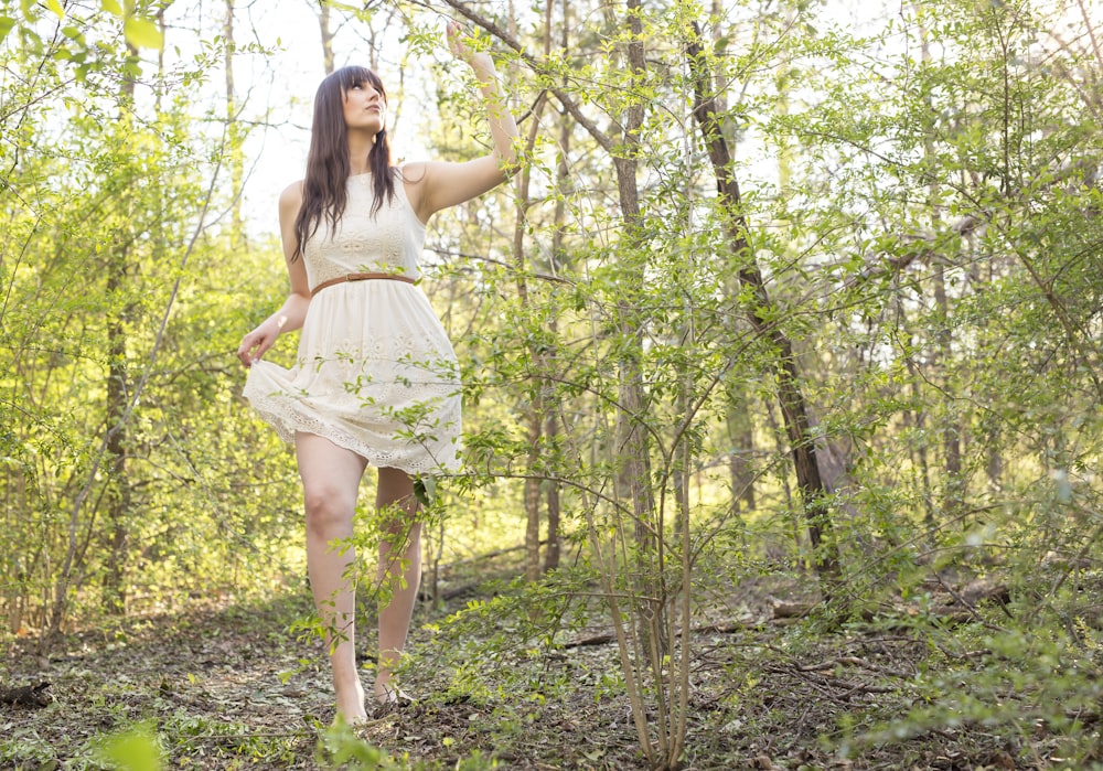 woman standing on side of plant wearing dress and barefoot