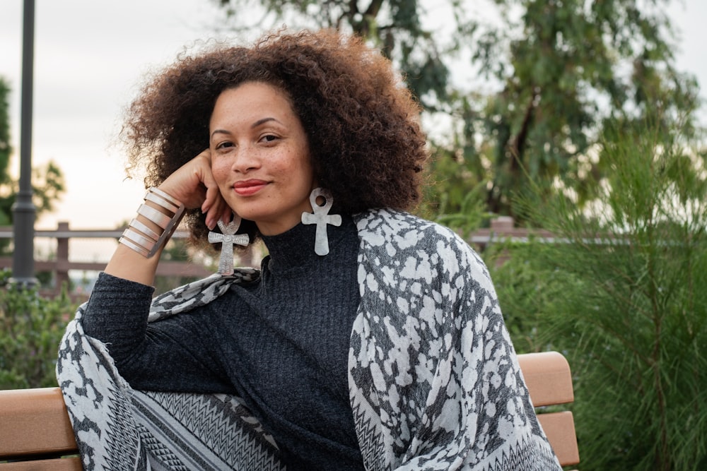 woman smiling while sitting on bench during daytime