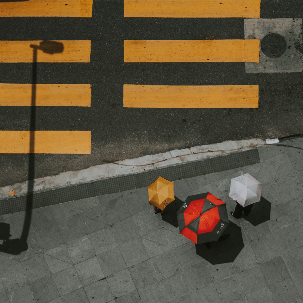 Draufsicht von drei verschiedenfarbigen Regenschirmen