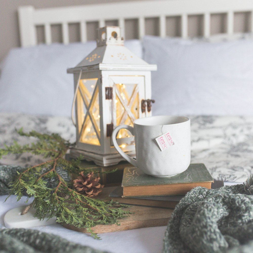 white ceramic mug and wooden candle holder
